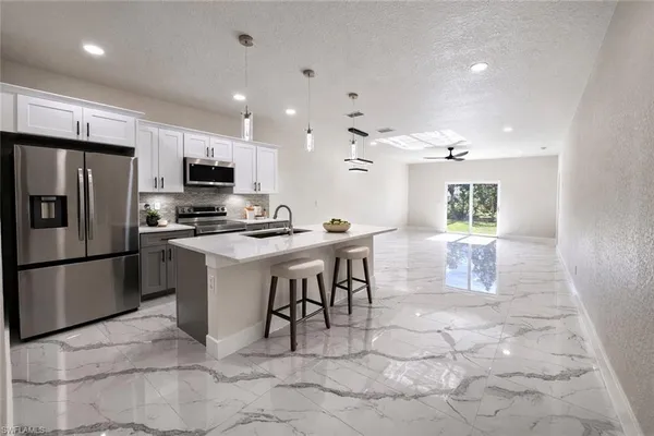 a kitchen with stainless steel appliances a refrigerator sink and microwave