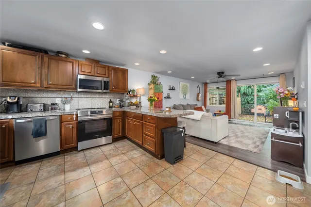 a kitchen with stainless steel appliances granite countertop a stove top oven a sink a counter top space and cabinets