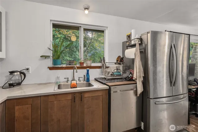 a kitchen with stainless steel appliances a sink stove and a refrigerator