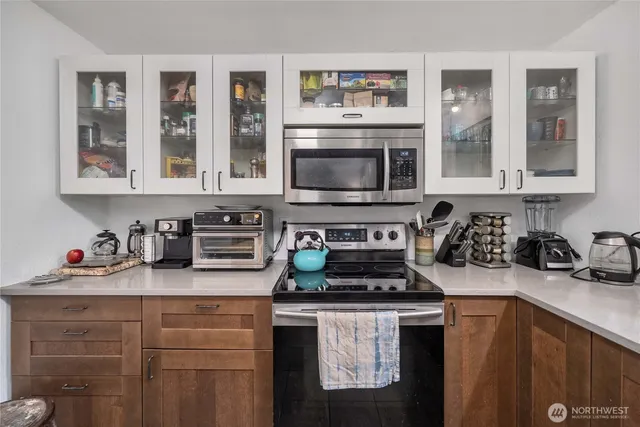 a kitchen with stainless steel appliances a stove a sink and a microwave