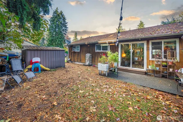 a view of backyard with outdoor seating and trees
