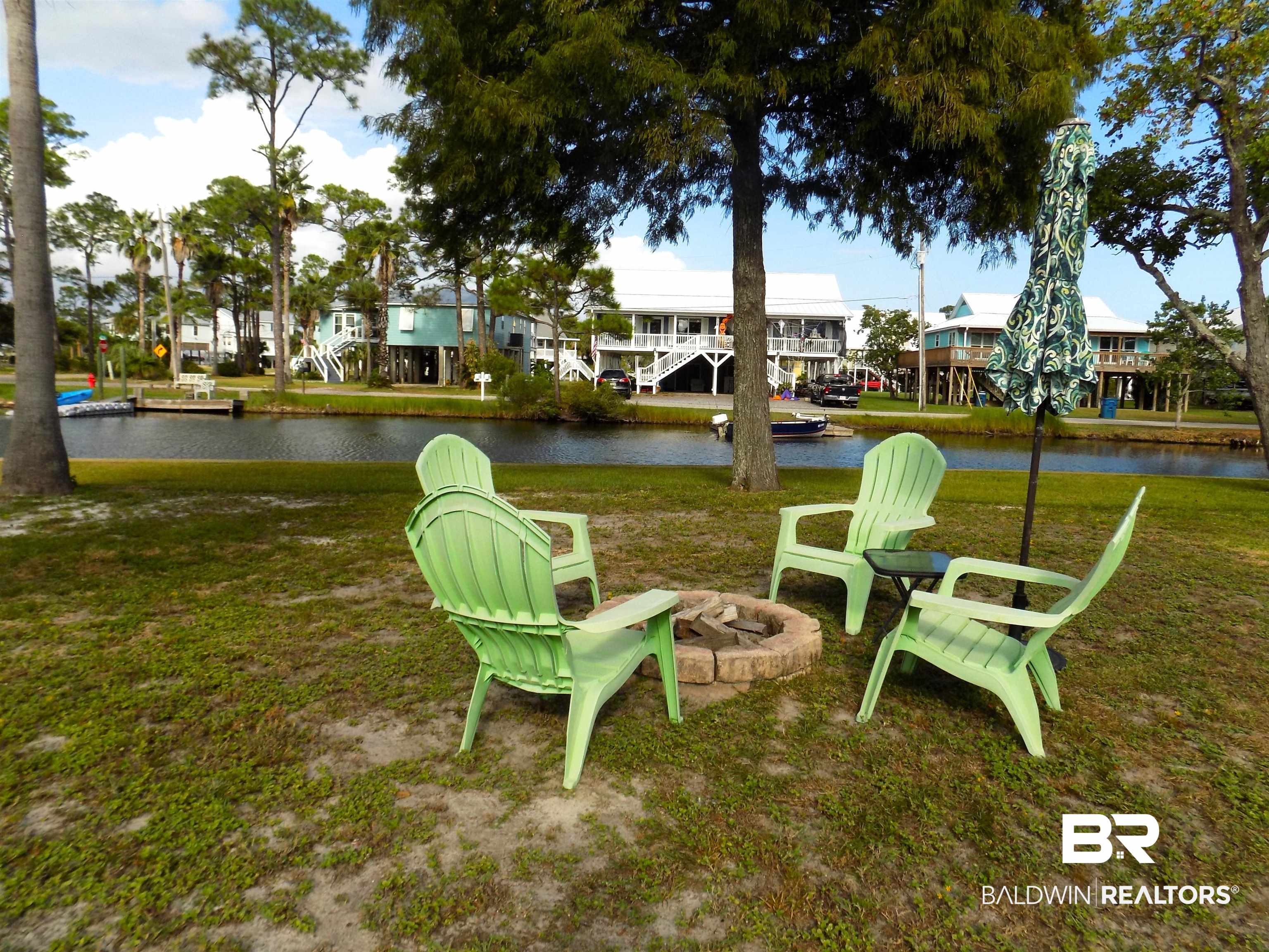 304 Windmill Ridge Road Gulf Shores, AL 36542 - Photo 22 of 29 View of grassy yard featuring a water view and an outdoor fire pit