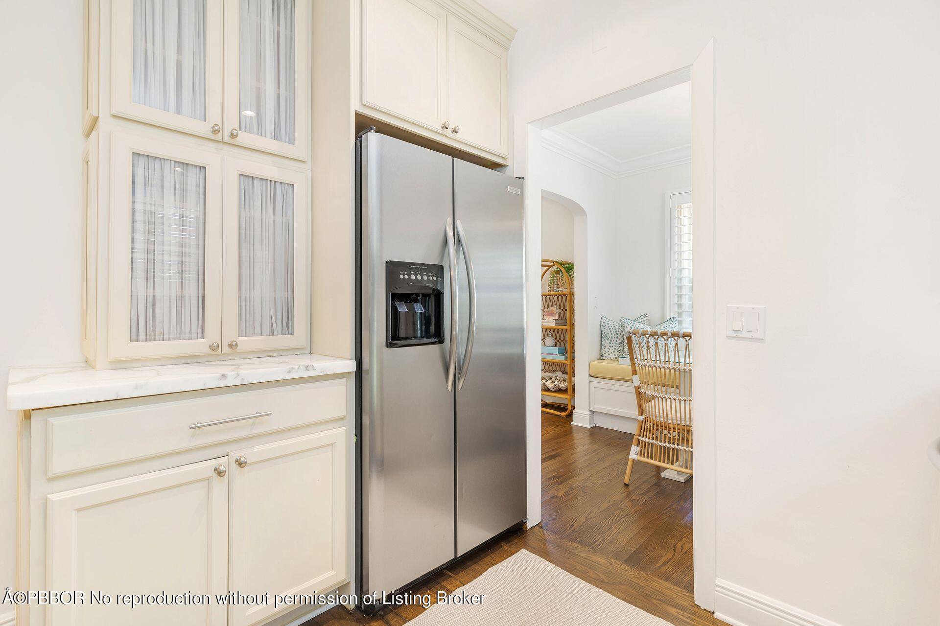 231 Cocoanut Row Palm Beach, FL 33480 - Photo 10 of 27 a kitchen with granite countertop a refrigerator and white cabinets