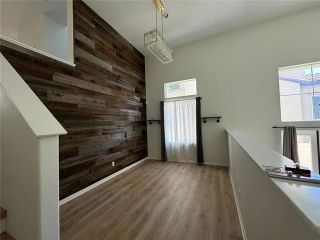 a view of a white house with a big yard plants and large trees