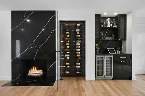 a dining room with stainless steel appliances a dining table wooden floor and a large window