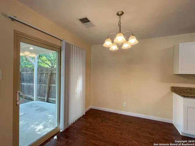 a view of a room with wooden floor and a chandelier