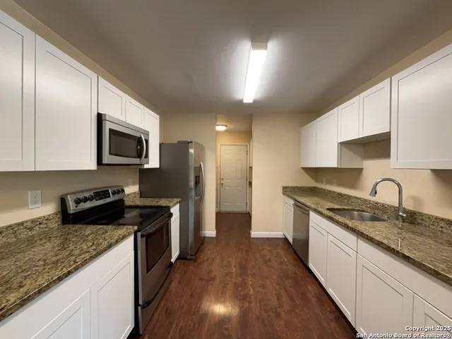 a kitchen with a sink stove top oven and refrigerator
