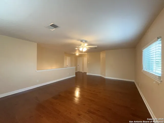 wooden floor in an empty room with a window