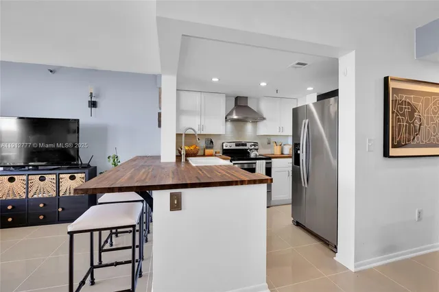 a kitchen with stainless steel appliances granite countertop a refrigerator a stove a microwave a sink and a refrigerator