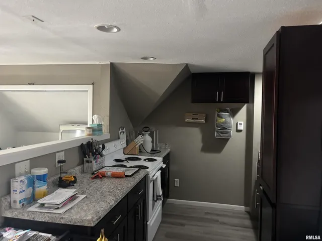 a kitchen with stainless steel appliances granite countertop a refrigerator a stove and a sink with wooden floor