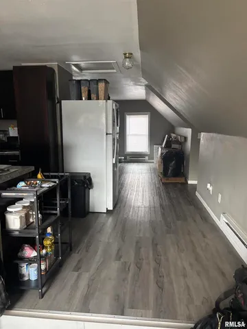 a view of kitchen and living room with wooden floor