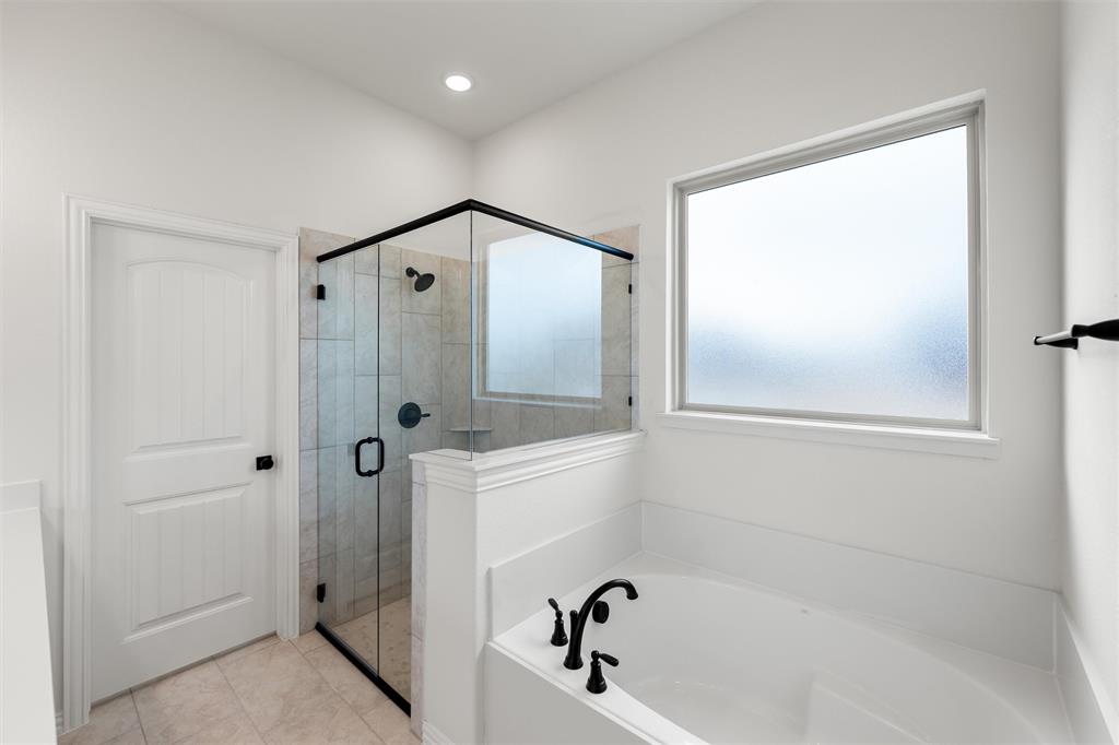 125 Snowy Owl Trail Rhome, TX 76078 - Photo 18 of 28 a bathroom with a bathtub and a shower