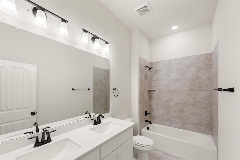 125 Snowy Owl Trail Rhome, TX 76078 - Photo 23 of 28 a bathroom with a bathtub shower sink vanity mirror and toilet