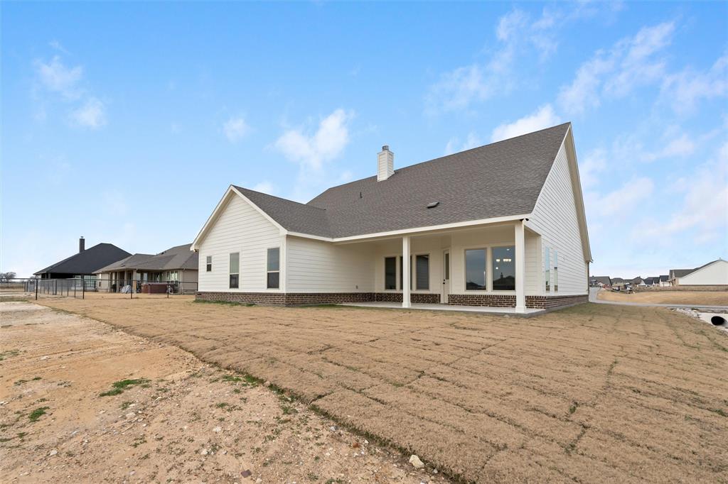 125 Snowy Owl Trail Rhome, TX 76078 - Photo 25 of 28 a front view of a house with a yard