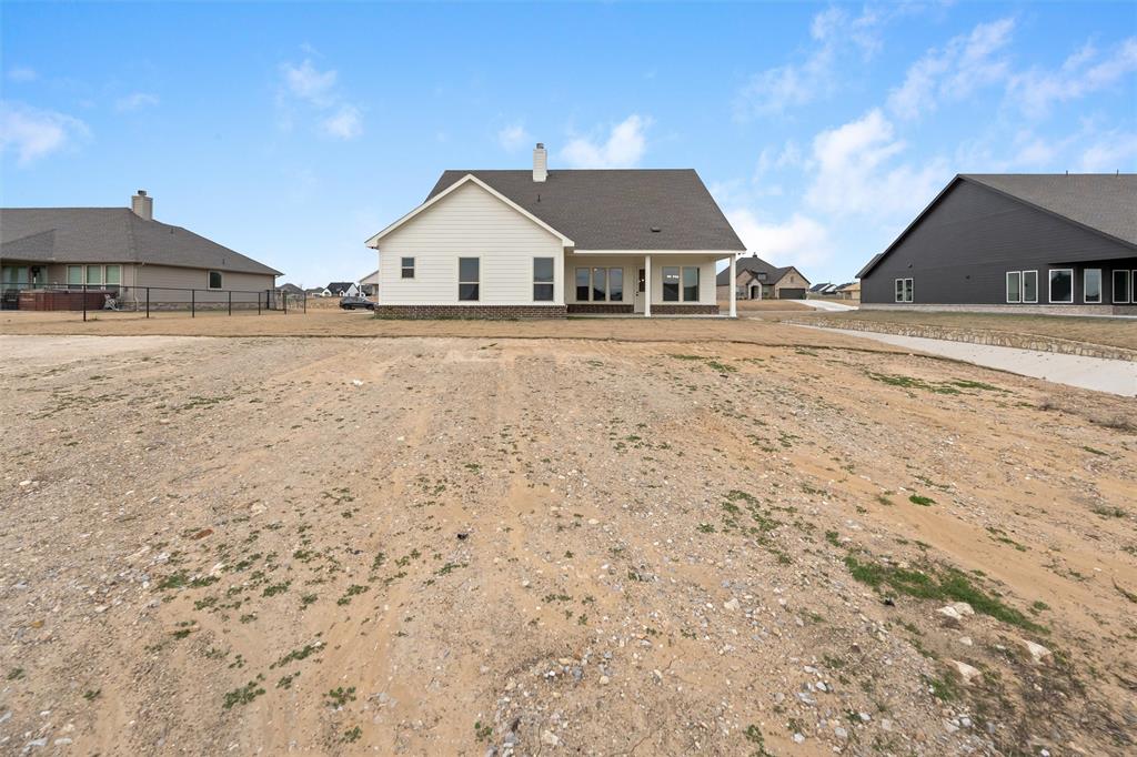 125 Snowy Owl Trail Rhome, TX 76078 - Photo 26 of 28 a view of house with wooden floor and fence