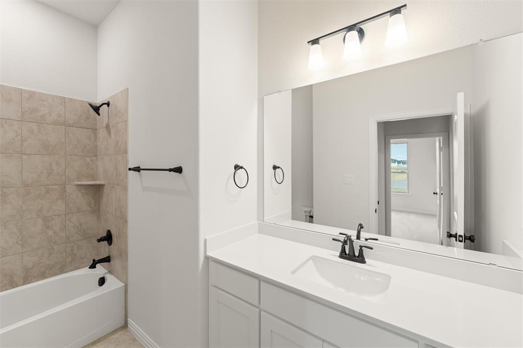 125 Snowy Owl Trail Rhome, TX 76078 - Photo 7 of 28 a bathroom with a bath tub sink and mirror