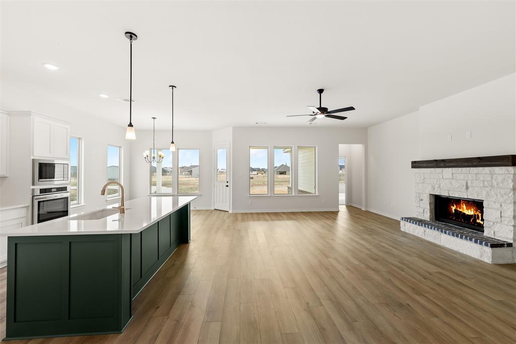 125 Snowy Owl Trail Rhome, TX 76078 - Photo 27 of 28 a large living room with stainless steel appliances granite countertop a fireplace a flat screen tv and a fireplace