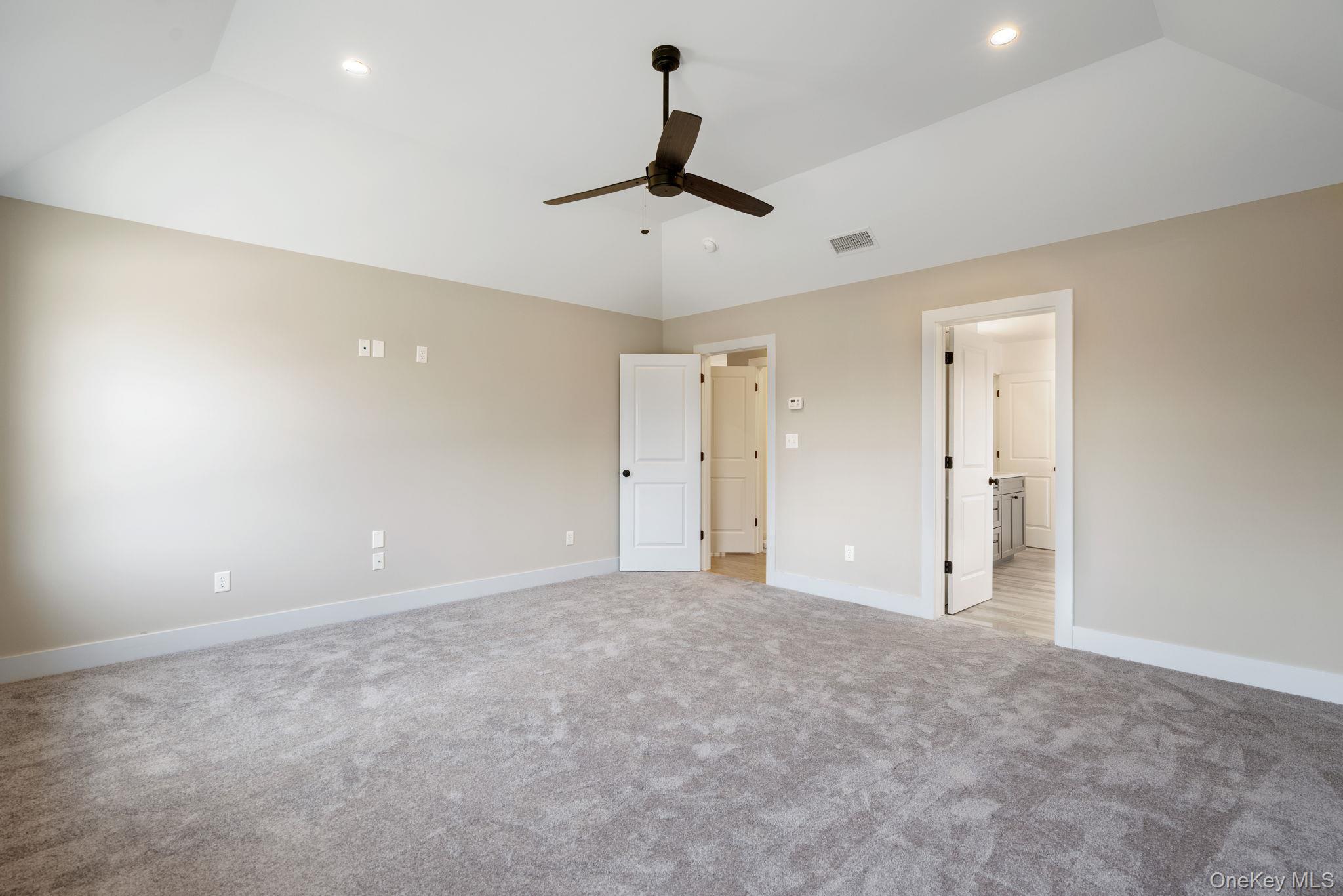 13 Harrier Ridge Drive Wallkill, NY 12589 - Photo 21 of 40 Unfurnished bedroom with vaulted ceiling, light colored carpet, ceiling fan, ensuite bathroom, and recessed lighting