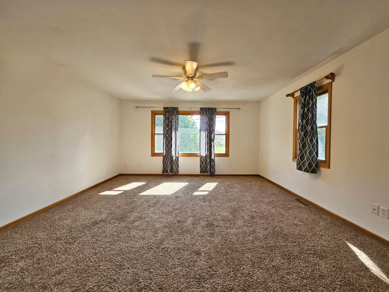 647 North Calumet Road Chesterton, IN 46304 - Photo 16 of 42 an empty room with windows and ceiling fan view