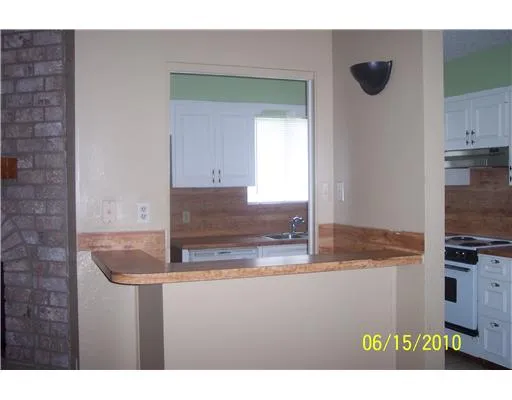 a kitchen with kitchen island granite countertop a sink a stove and cabinets