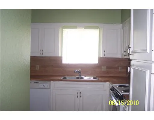 a kitchen with a sink cabinets and a window
