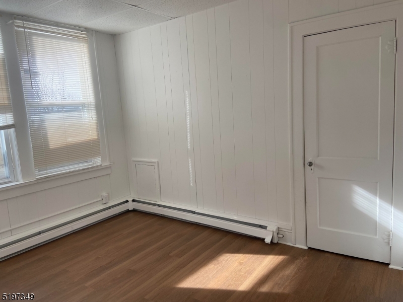 126 Main Street, Unit E Franklin, NJ 07416 - Photo 4 of 7 an empty room with wooden floor and windows