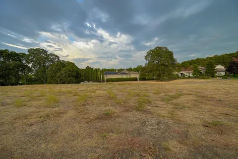 a view of swimming pool with lawn chairs and iron fence