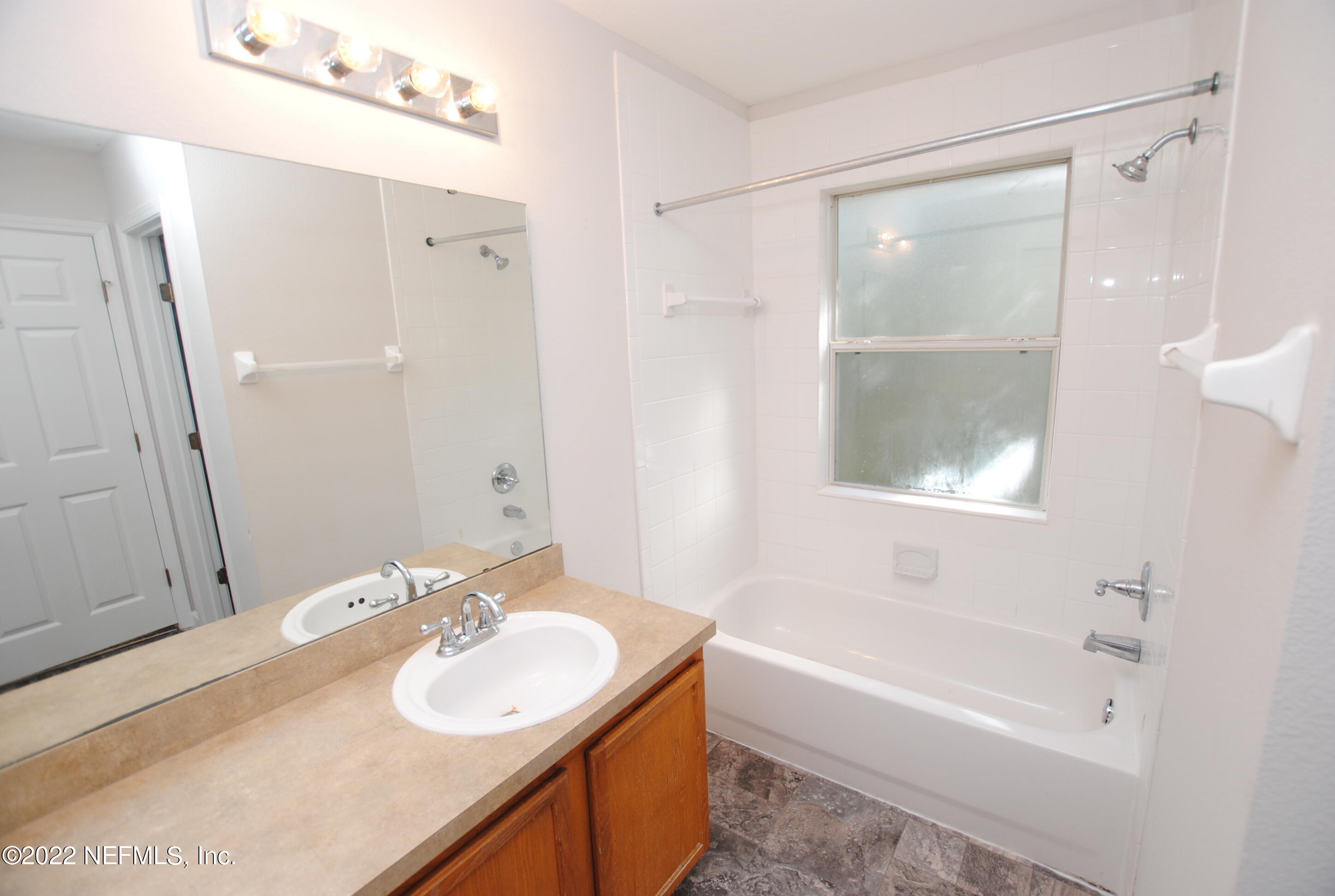 5260 Collins Road, Unit 505 Jacksonville, FL 32244 - Photo 14 of 20 a bathroom with a sink mirror toilet and bathtub