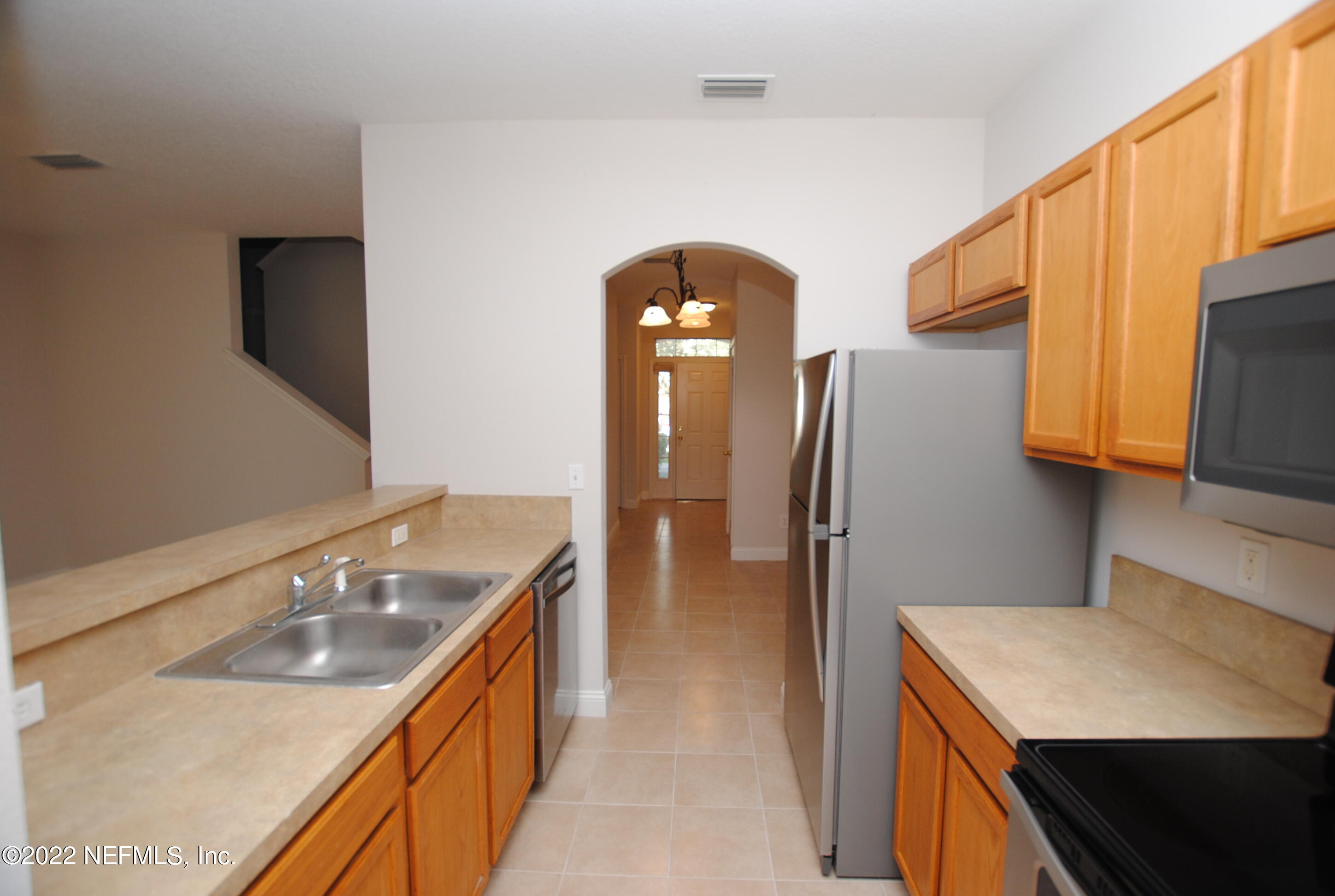 5260 Collins Road, Unit 505 Jacksonville, FL 32244 - Photo 3 of 20 a kitchen with stainless steel appliances granite countertop a sink a refrigerator and a stove