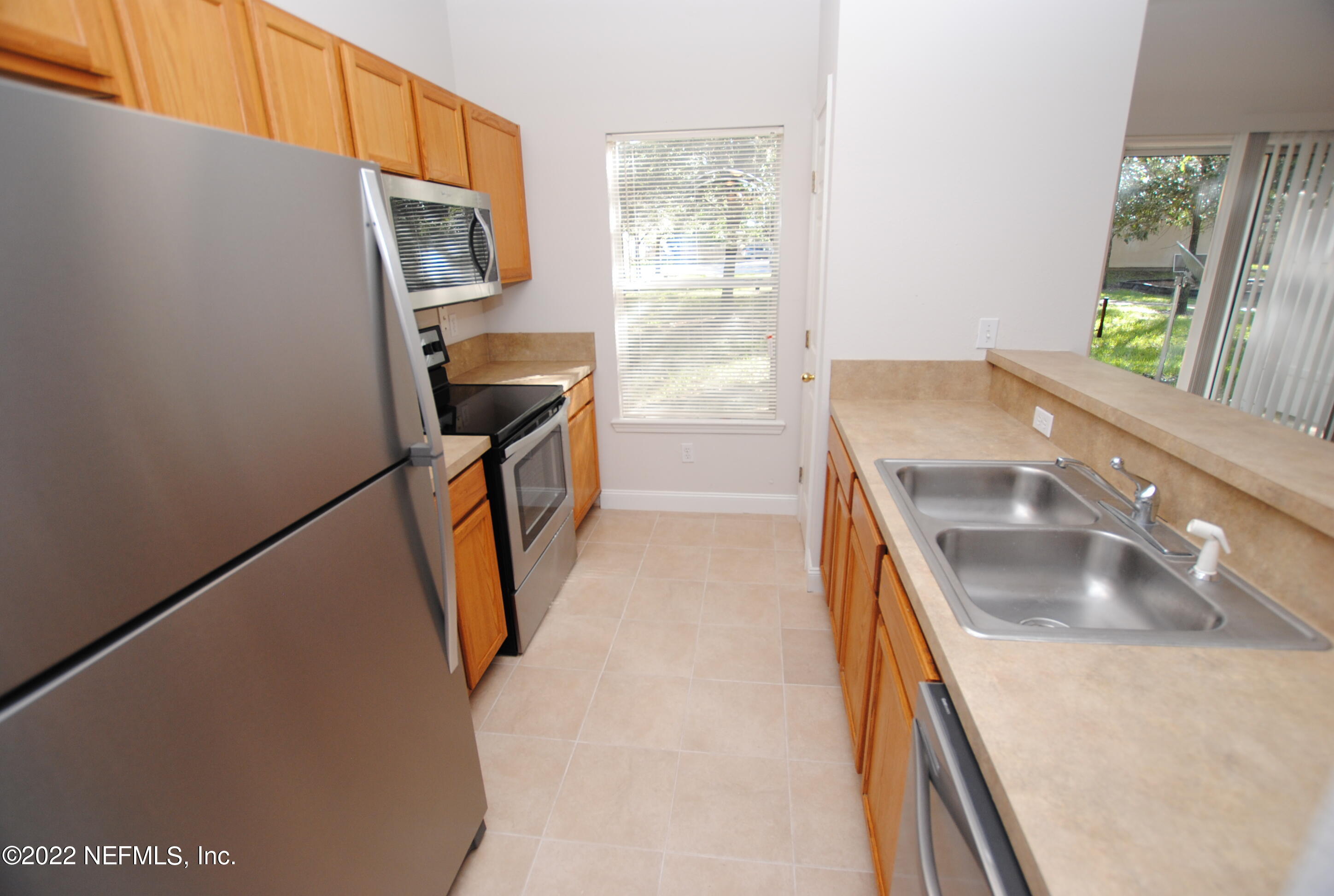 5260 Collins Road, Unit 505 Jacksonville, FL 32244 - Photo 4 of 20 a kitchen with a sink a stove and a refrigerator