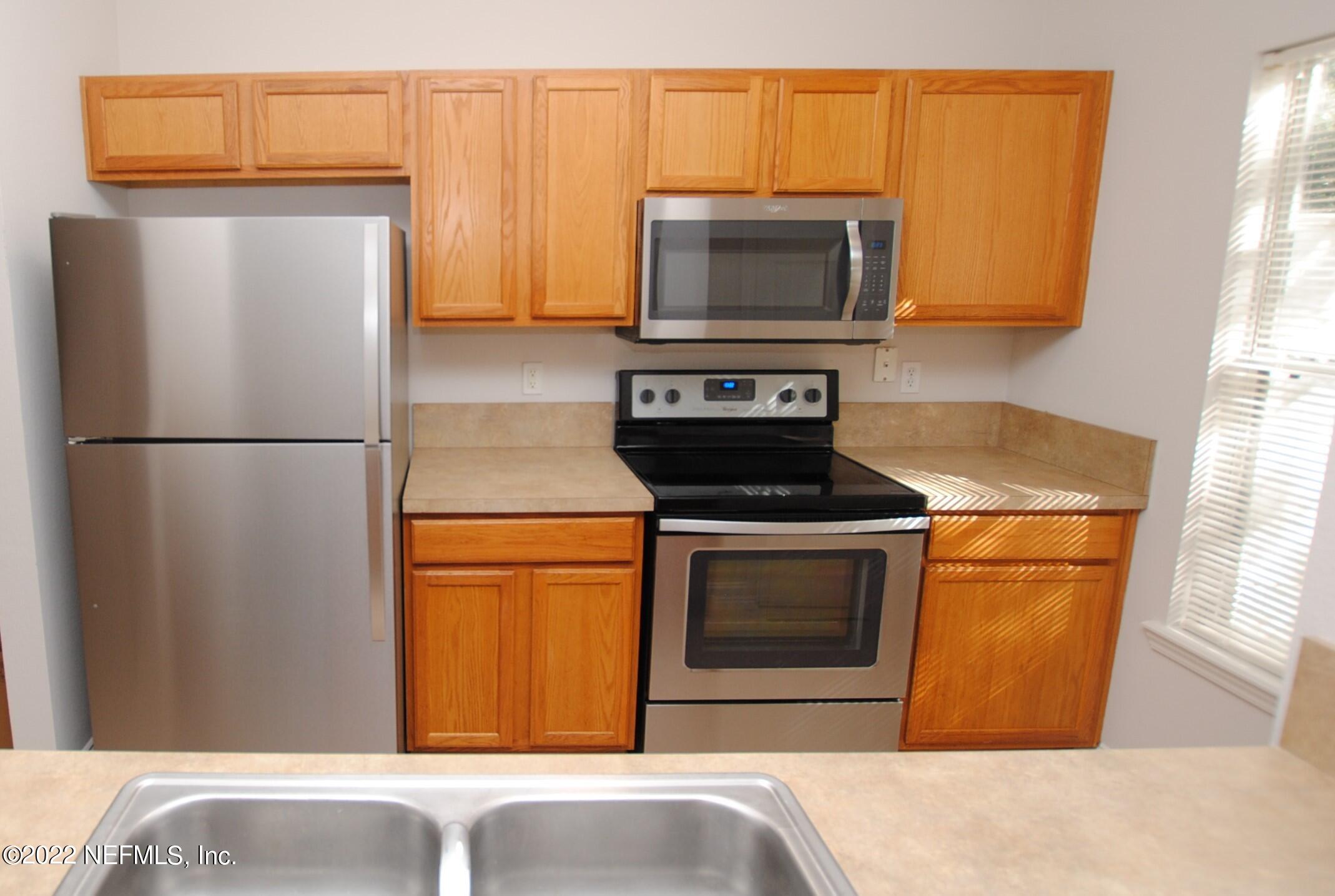 5260 Collins Road, Unit 505 Jacksonville, FL 32244 - Photo 5 of 20 a kitchen with stainless steel appliances a stove microwave and refrigerator