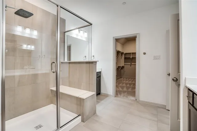 a bathroom with a glass shower door and a glass door