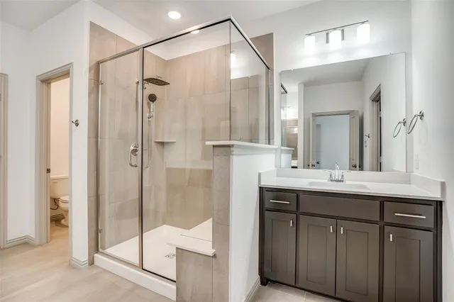 a bathroom with a shower sink and mirror