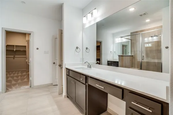 a bathroom with a sink a large mirror and a shower