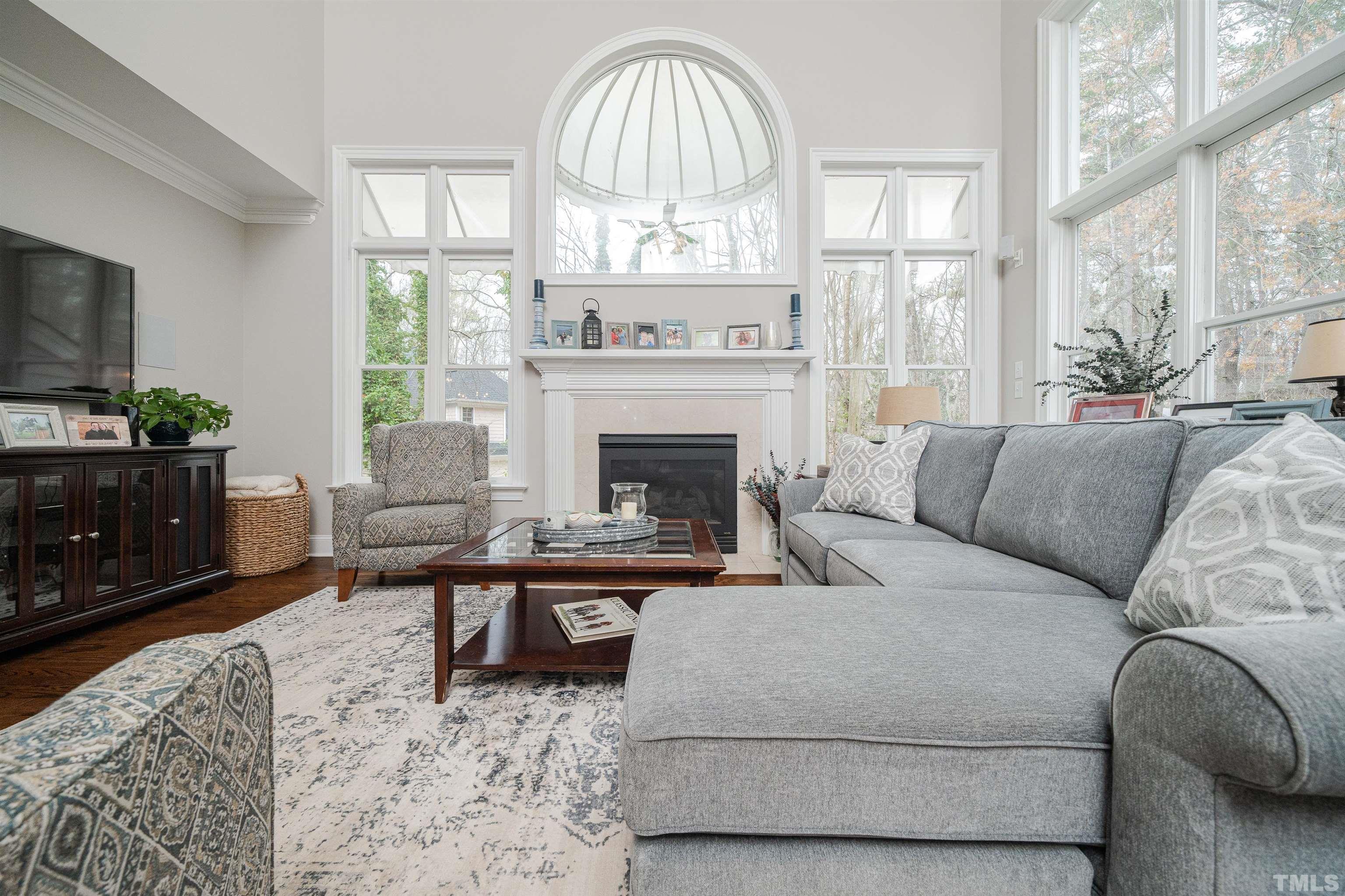 621 Bent Ridge Place Raleigh, NC 27615 - Photo 10 of 36 a living room with furniture a fireplace and a flat screen tv