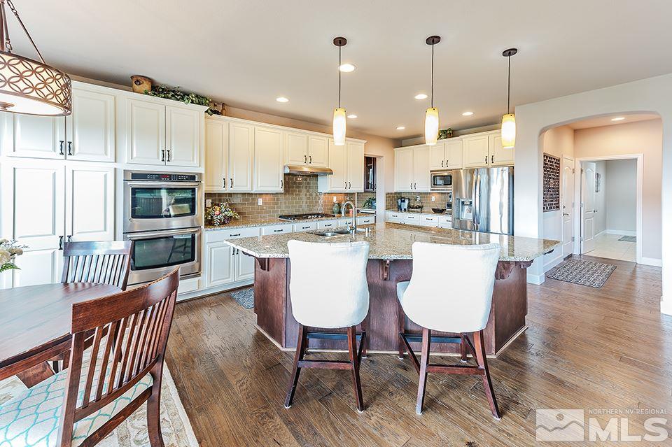 8564 Gypsy Hill Trail Reno, NV 89523 - Photo 19 of 25 a dining room filled chandelier and wooden floor