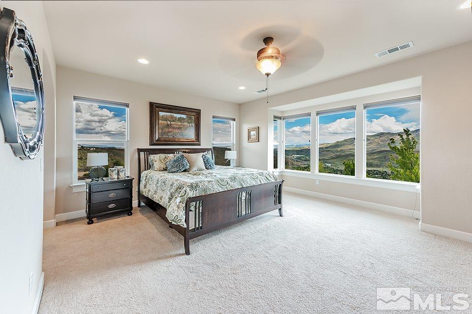 8564 Gypsy Hill Trail Reno, NV 89523 - Photo 8 of 25 a spacious bedroom with a large bed and a chandelier