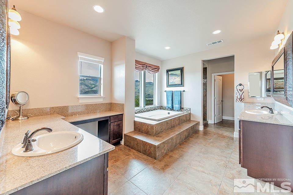 8564 Gypsy Hill Trail Reno, NV 89523 - Photo 10 of 25 a spacious bathroom with a granite countertop tub sink and mirror