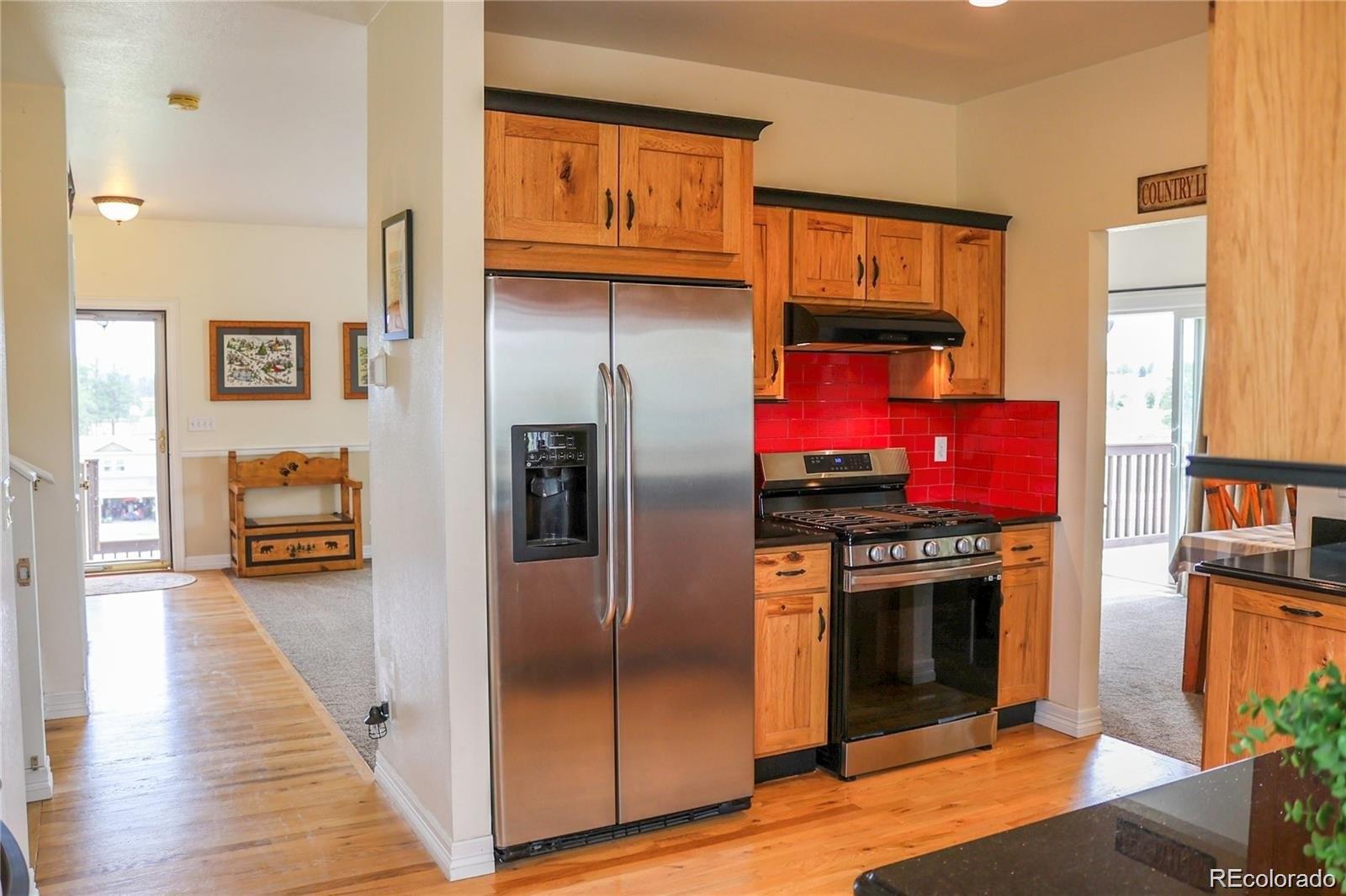 2501 Remington Road Elizabeth, CO 80107 - Photo 11 of 33 a kitchen with stainless steel appliances granite countertop a refrigerator a stove and a wooden floors