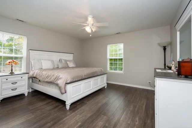 a spacious bedroom with a bed and a ceiling fan