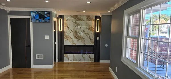 a view of a hallway with wooden floor and windows