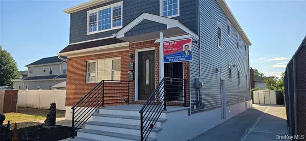 a view of a house with wooden stairs and a large tree