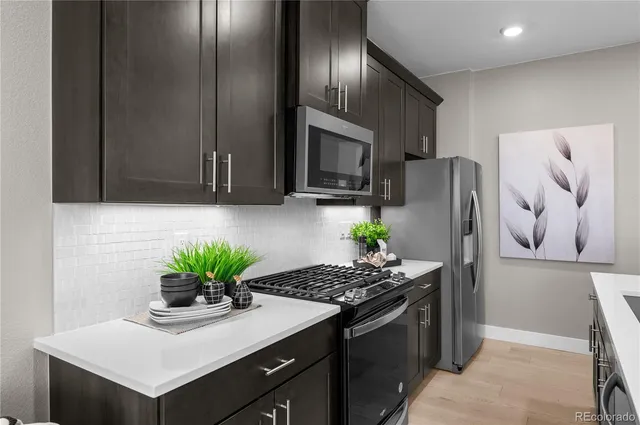 a kitchen with stainless steel appliances granite countertop a refrigerator a stove a sink and a refrigerator