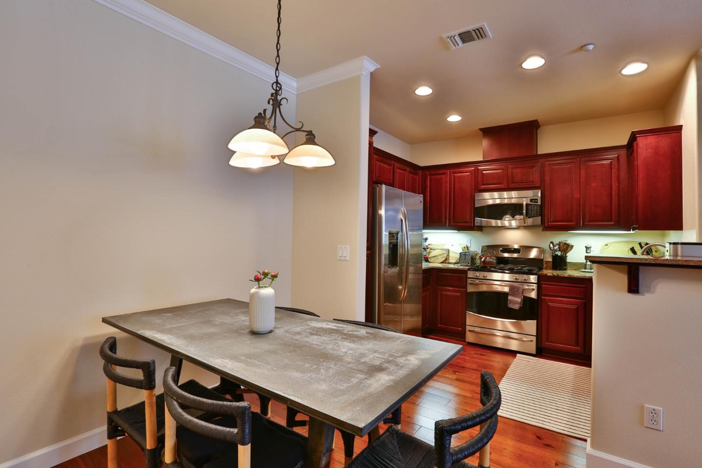3465 Dublin Boulevard, Unit 111 Dublin, CA 94568 - Photo 4 of 21 a kitchen with stainless steel appliances granite countertop a stove a refrigerator a sink a stove a dining table and chairs