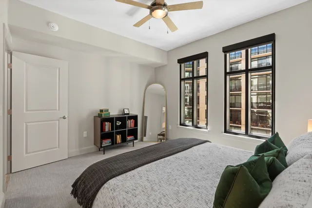 a bedroom with a bed and a large window