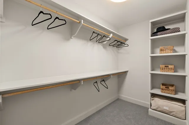 a view of a kitchen with rack on the wall and a window