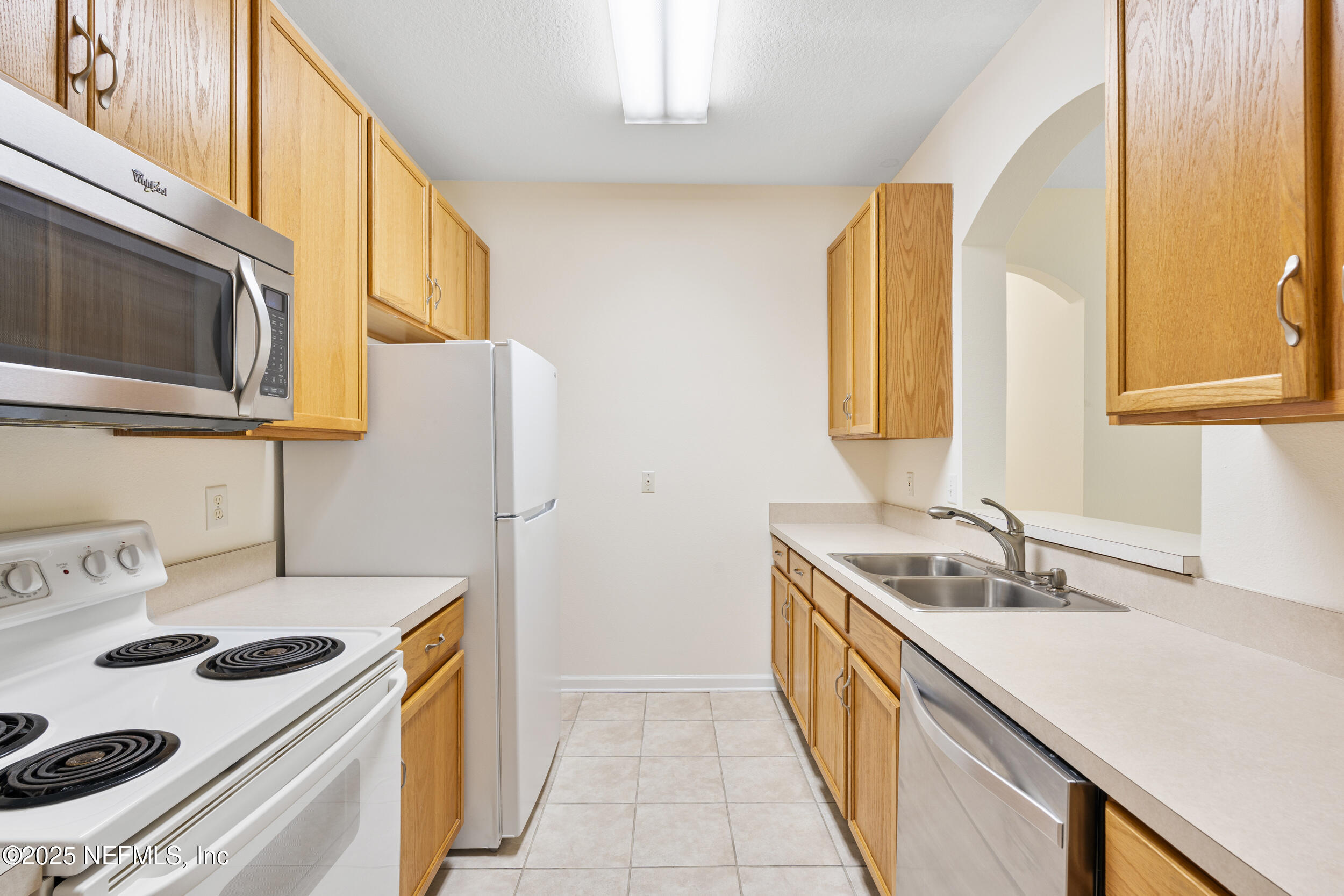 7990 Baymeadows Road East, Unit 120 Jacksonville, FL 32256 - Photo 7 of 38 a kitchen with a sink stove top oven and cabinets