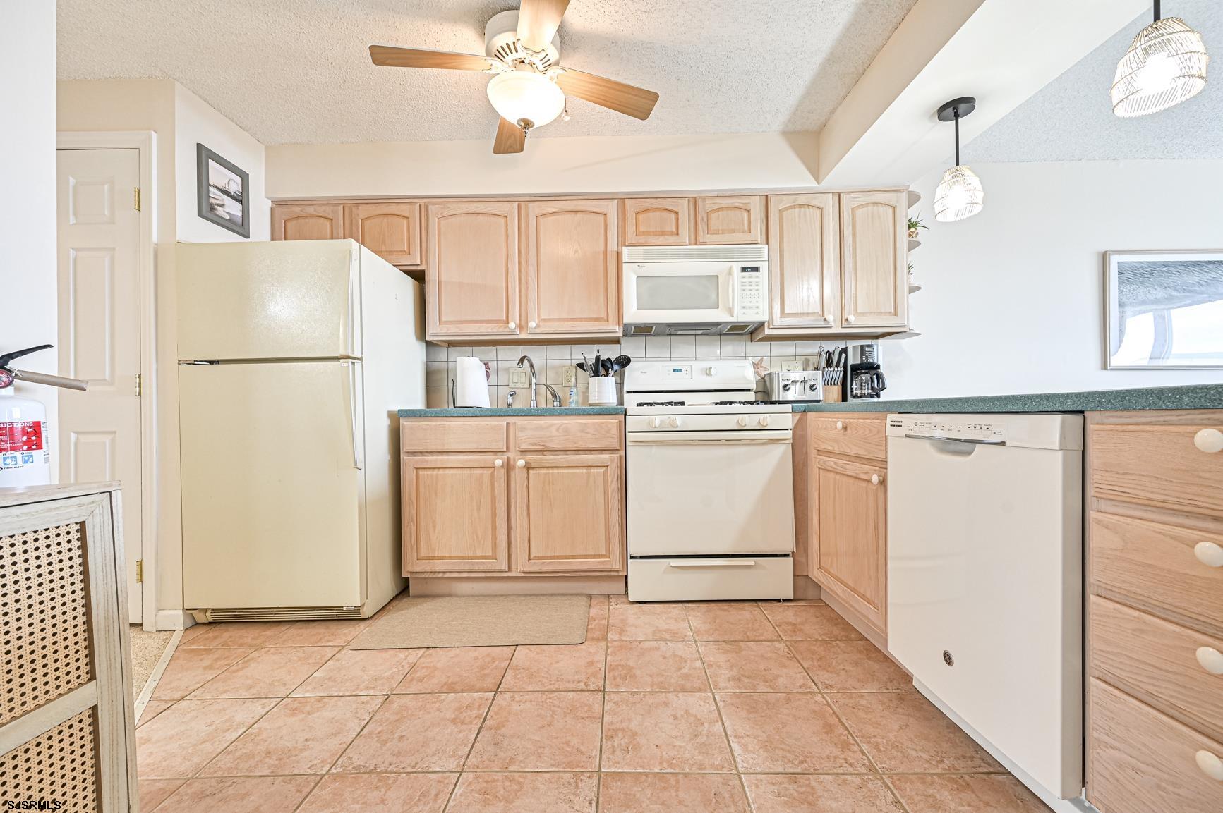 400 East Brigantine Avenue, Unit 2C Brigantine, NJ 08203 - Photo 9 of 37 a kitchen with white cabinets and white appliances
