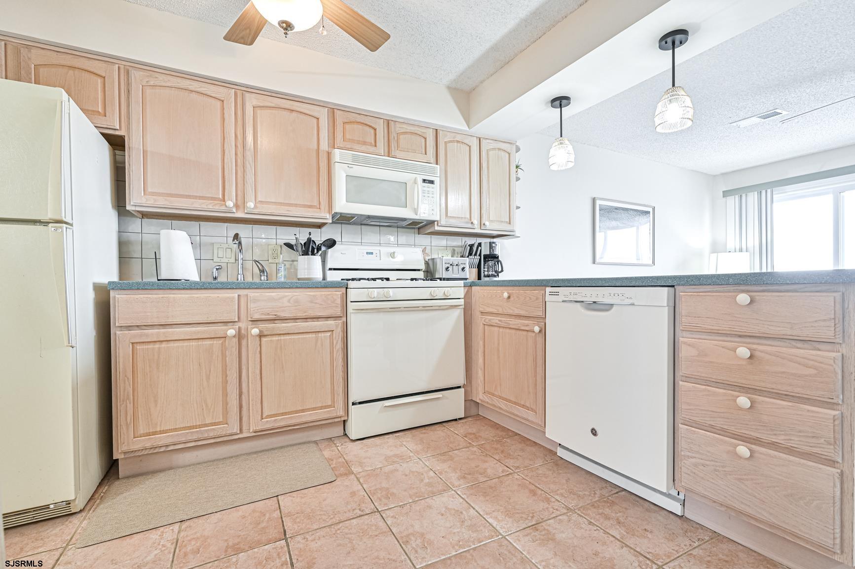 400 East Brigantine Avenue, Unit 2C Brigantine, NJ 08203 - Photo 10 of 37 a kitchen with white cabinets and white appliances
