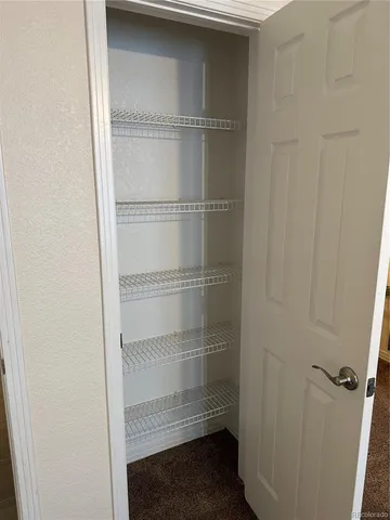 a view of walk in closet with empty racks